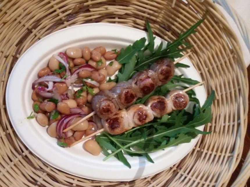 Purcitoro in Cuccagna: spiedini di toro e lonza arrotolati su salsiccia - con tris di fagioli su letto di rucola.